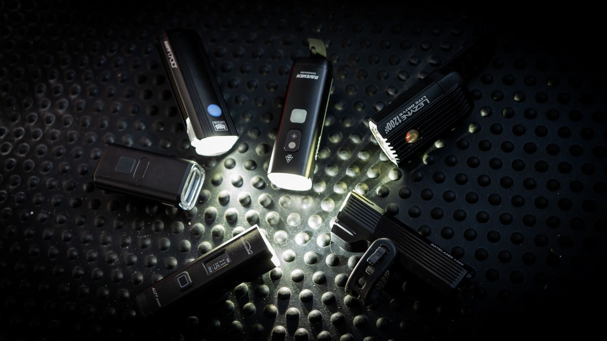 Best Bike Lights grouptest lead image by Cycling Weekly 2025. 6 bike lights all turned on facing each other in a circle. 