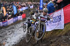 Mathieu van der Poel running up a muddy slope at a cyclo-cross race