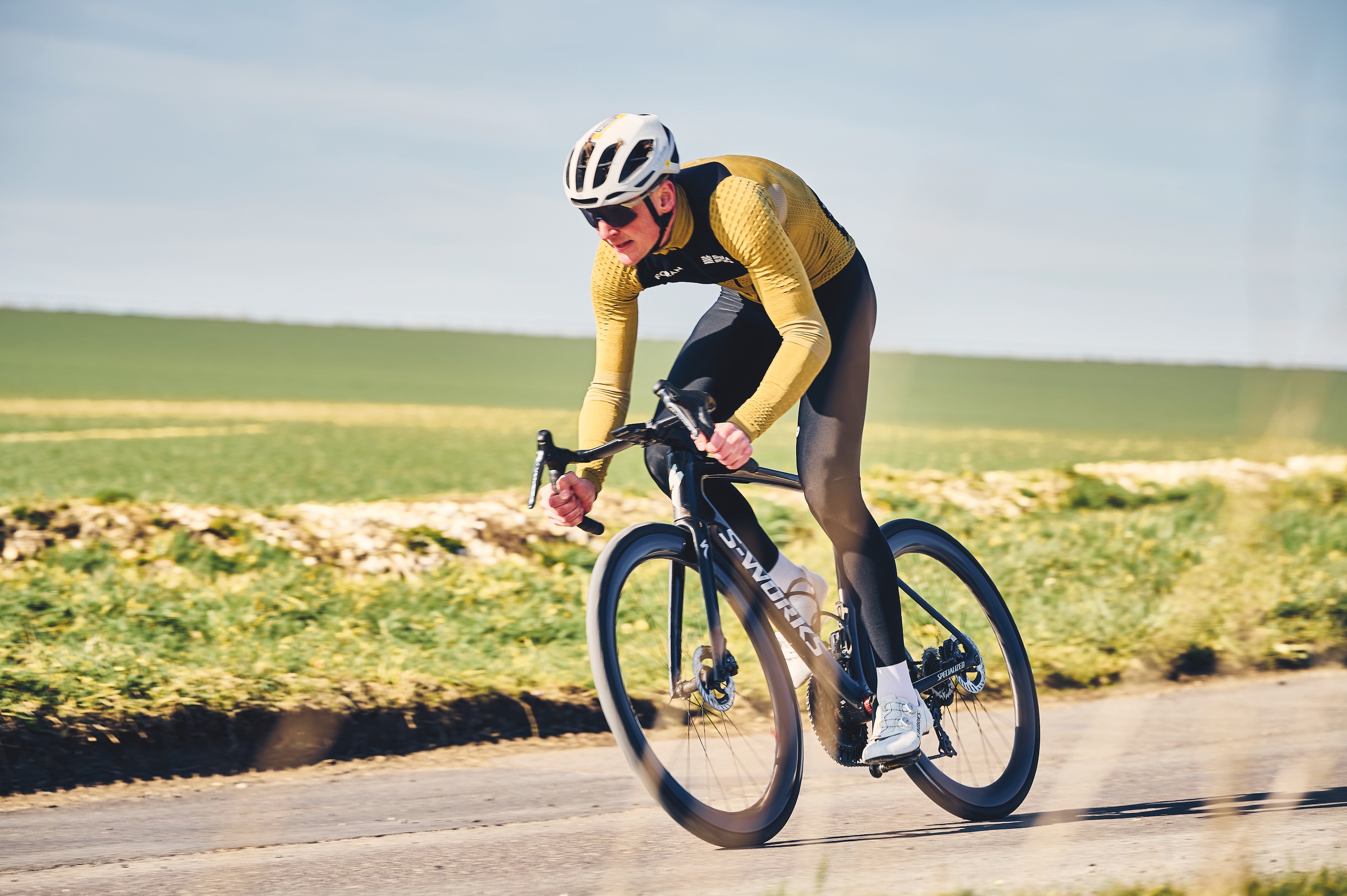 Dom Jackson riding in a yellow and black long-sleeve jersey